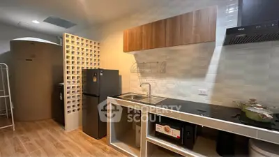 Modern kitchen with sleek appliances and stylish cabinetry in a contemporary apartment.