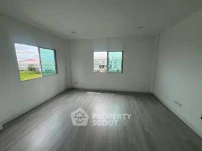 Spacious empty room with large windows and modern flooring, ideal for customization.
