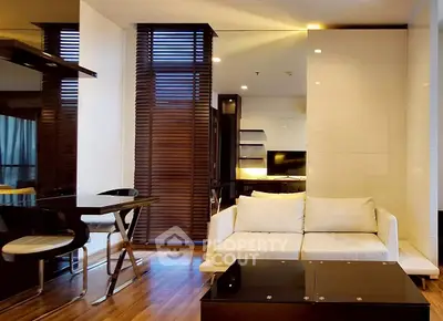 Modern living room with sleek furniture and wooden flooring in a stylish apartment.