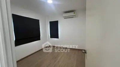 Minimalist empty room with wooden flooring and air conditioning unit