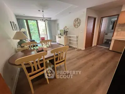 Charming dining area with elegant wooden table and chairs, adjacent to a cozy living space with natural light.