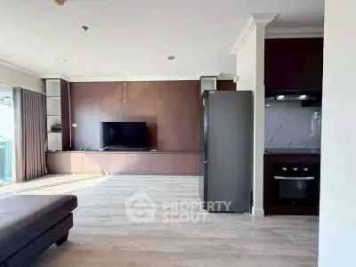 Spacious modern living room with sleek wooden paneling and built-in TV unit, featuring a contemporary kitchen area.