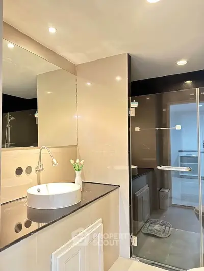 Modern bathroom with glass shower and sleek vanity in a contemporary home.