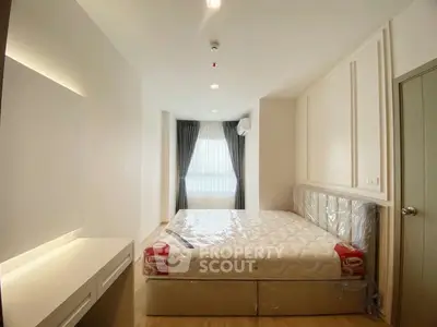 Modern bedroom with natural light and minimalist design, featuring a comfortable bed and sleek furnishings.