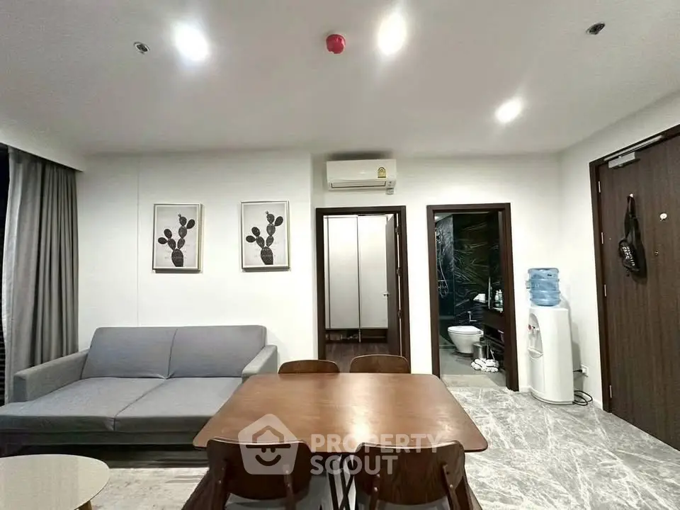 Modern living room with dining area, featuring sleek furniture and contemporary decor.