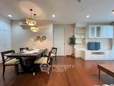 Elegant living room with wooden flooring, stylish dining area, and modern entertainment unit.