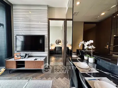 Modern living room with sleek TV setup and elegant dining area in luxury apartment.