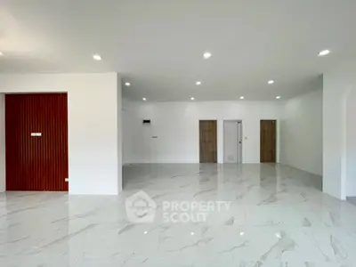 Spacious modern living room with marble flooring and recessed lighting