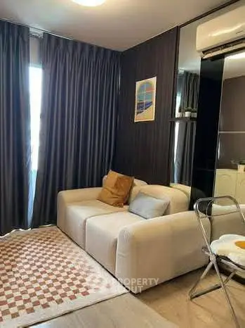 Cozy living room with modern decor and natural light, featuring a plush sofa and stylish curtains.