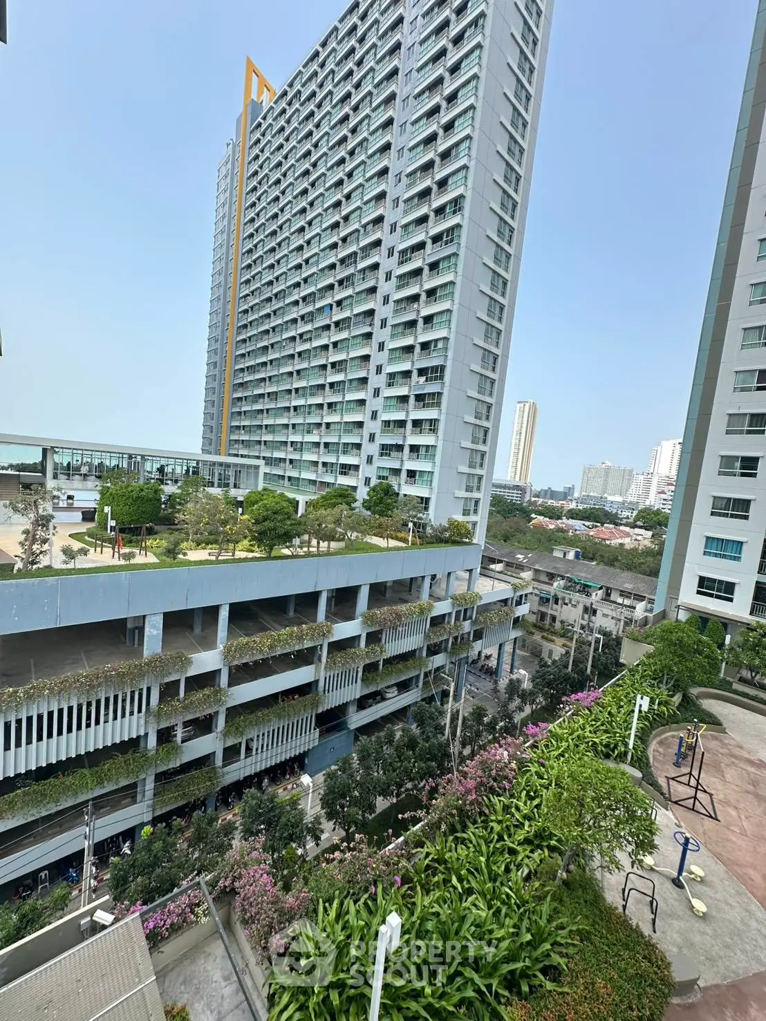 Modern high-rise building with lush greenery and urban view