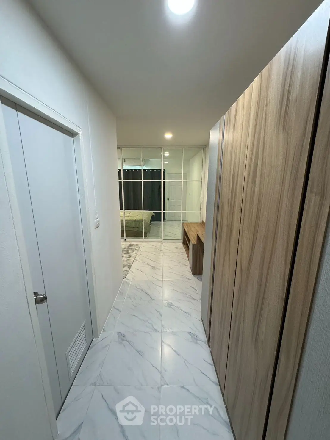 Modern hallway with marble flooring leading to a stylish bedroom