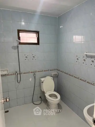 Spacious bathroom with blue tiles and modern fixtures in a real estate property.