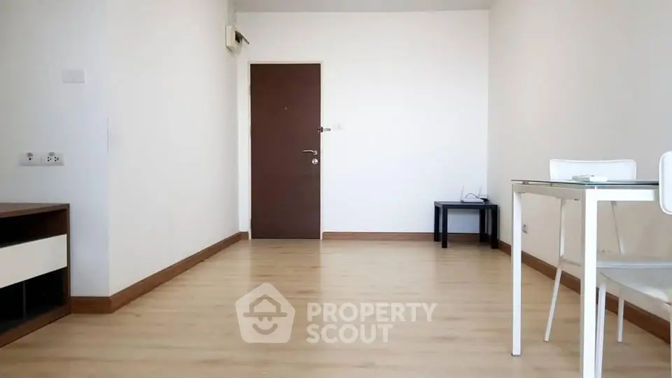 Spacious minimalist living room with wooden flooring and modern furniture.