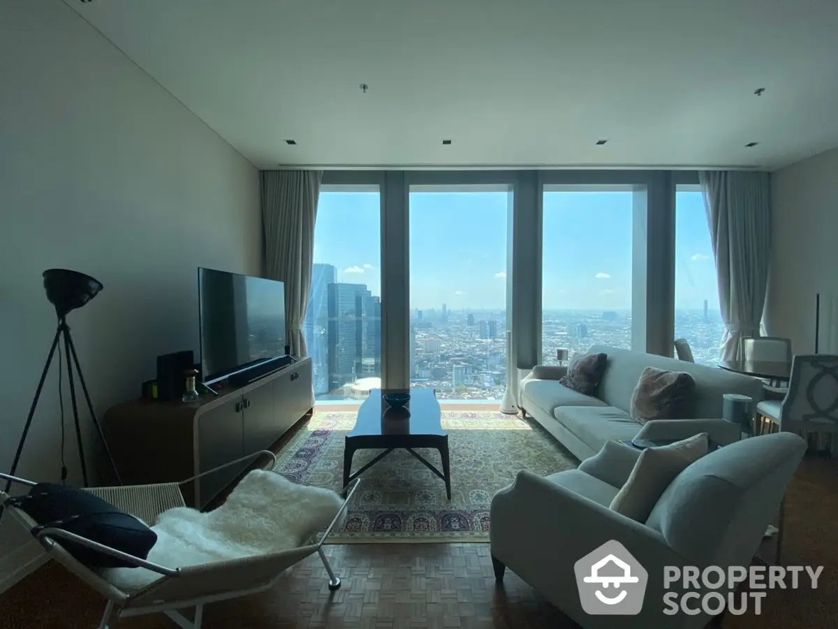 Spacious living room with modern furnishings and floor-to-ceiling windows offering a panoramic city view, bathed in natural light.