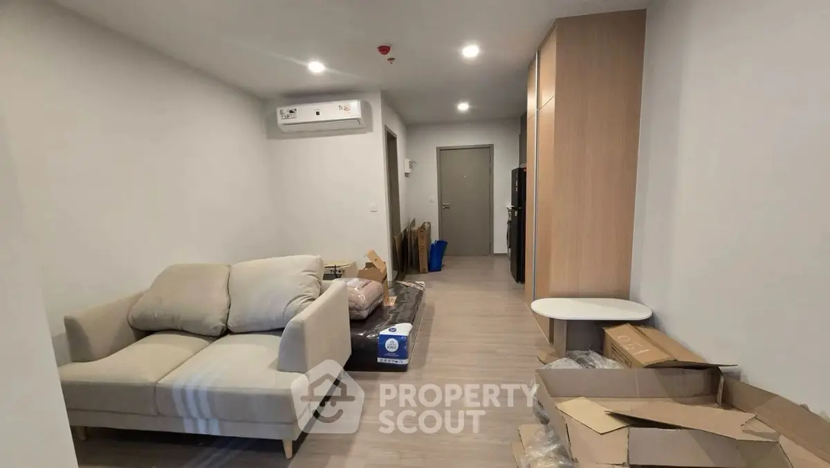 Modern living room with cozy sofa and sleek wooden flooring in a contemporary apartment.