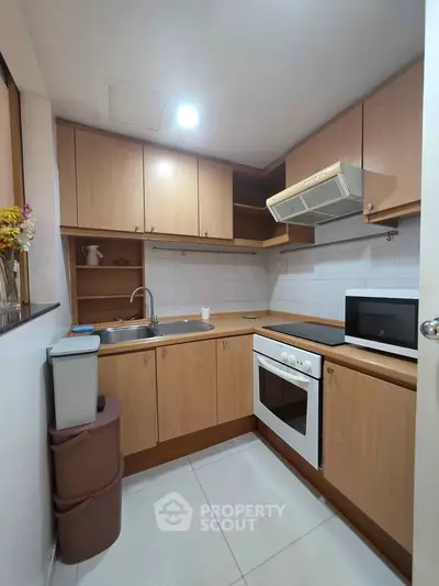 Cozy kitchen with wooden cabinets, modern appliances, and ample storage space.