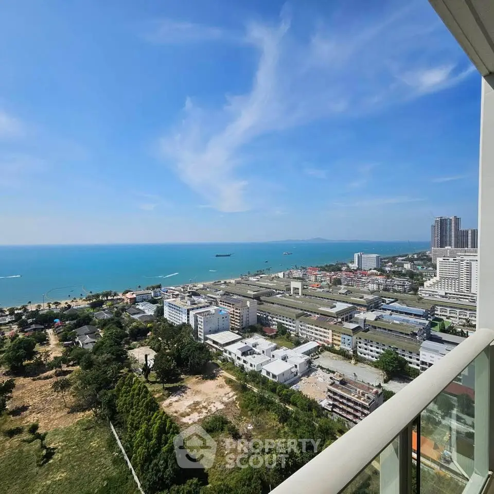 Stunning high-rise balcony view overlooking cityscape and ocean, perfect for urban living with a serene touch.