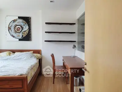 Cozy bedroom with wooden furniture and modern art decor, perfect for relaxation and work-from-home setup.