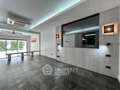 Spacious modern living room with large windows and stylish lighting, perfect for contemporary living.
