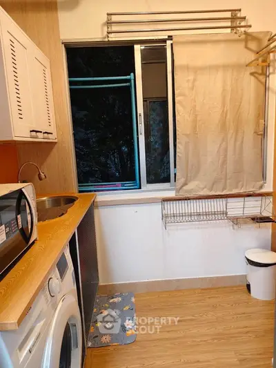 Cozy laundry room with washing machine and wooden countertop