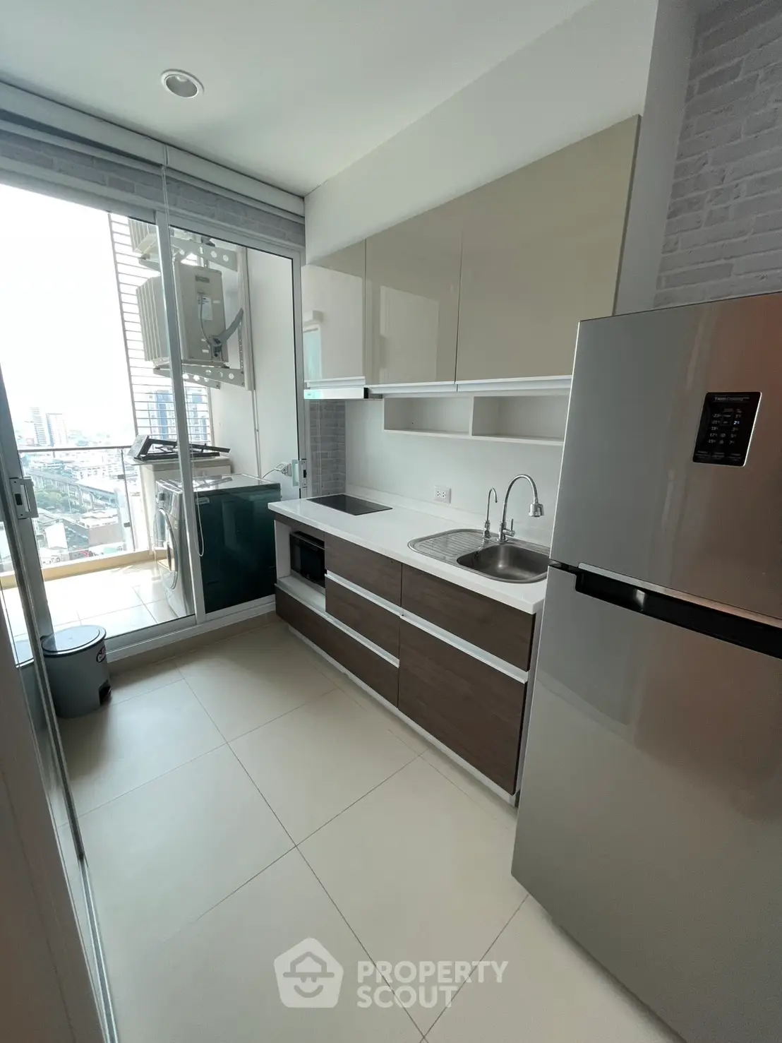 Modern kitchen with sleek cabinets and city view balcony