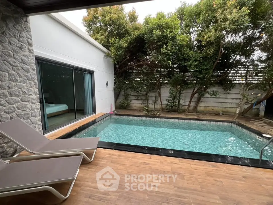 Luxurious private pool area with sun loungers and lush greenery, perfect for relaxation and leisure.