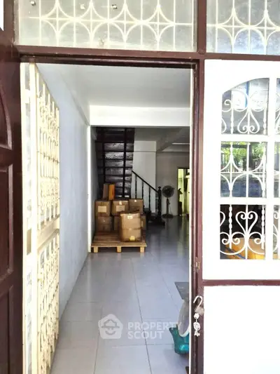 Spacious entryway with boxes and staircase, ideal for storage or renovation.