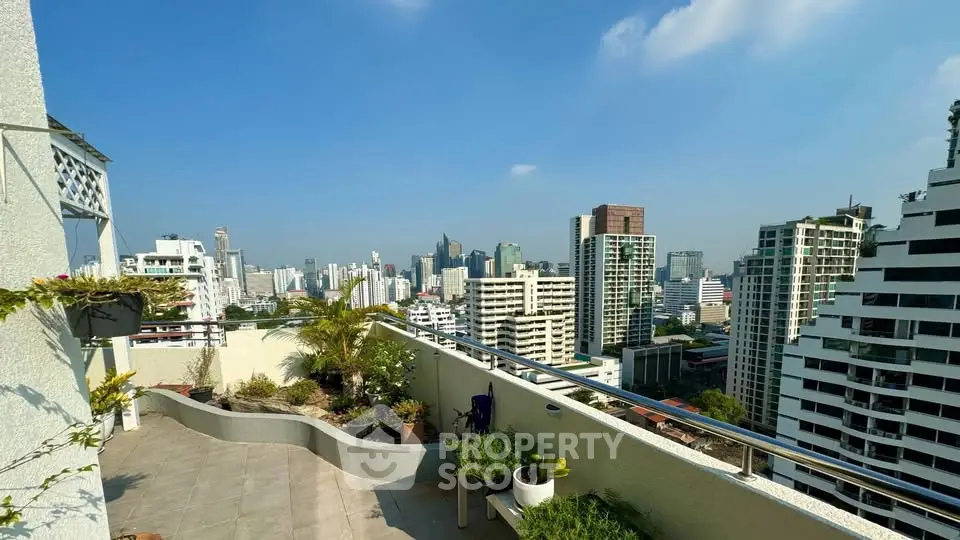 Stunning rooftop terrace with panoramic city skyline views and lush greenery.