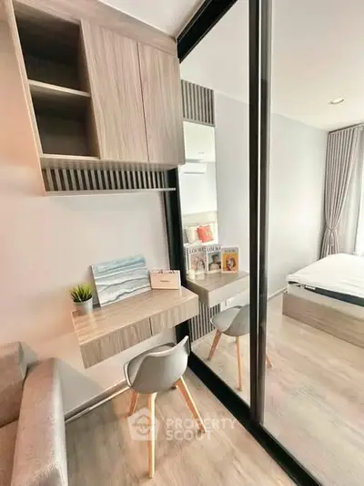 Modern bedroom with stylish study area and mirrored wardrobe in a contemporary apartment.