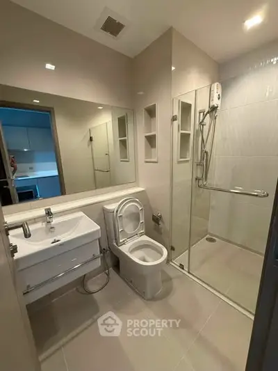 Modern bathroom with glass shower and sleek fixtures in a contemporary apartment.