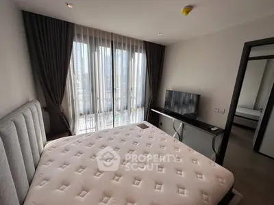 Spacious bedroom with large windows and modern furnishings in a high-rise apartment.