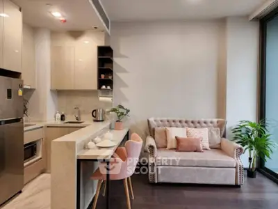 Chic open-plan living space with modern kitchen, stainless steel appliances, and cozy sitting area, perfect for urban living.