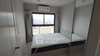 Modern bedroom with city view and large window in high-rise apartment