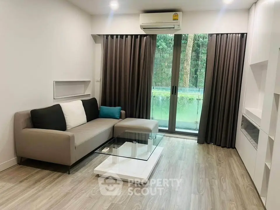 Modern living room with sleek design, featuring a cozy sofa, glass coffee table, and large window with garden view.