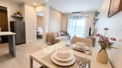 Modern open-plan living room with dining area and cozy bedroom view