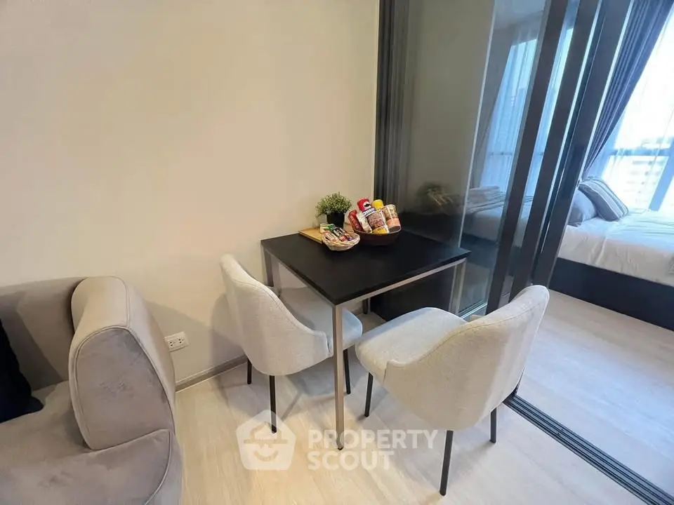 Modern apartment with cozy dining area and glass partitioned bedroom, perfect for urban living.