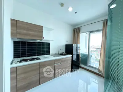 Modern kitchen with sleek cabinets and balcony view in a stylish apartment
