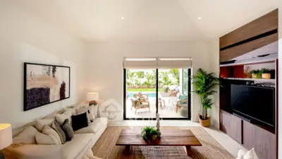 Luxurious living room with pool view, elegant decor, and natural light