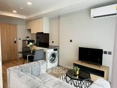 Modern living room with open kitchen, washing machine, and air conditioning in a stylish apartment.