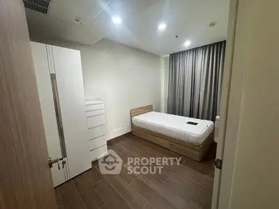 Modern minimalist bedroom with wooden flooring and sleek furniture