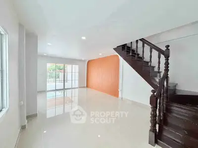 Spacious modern living room with elegant staircase and large windows
