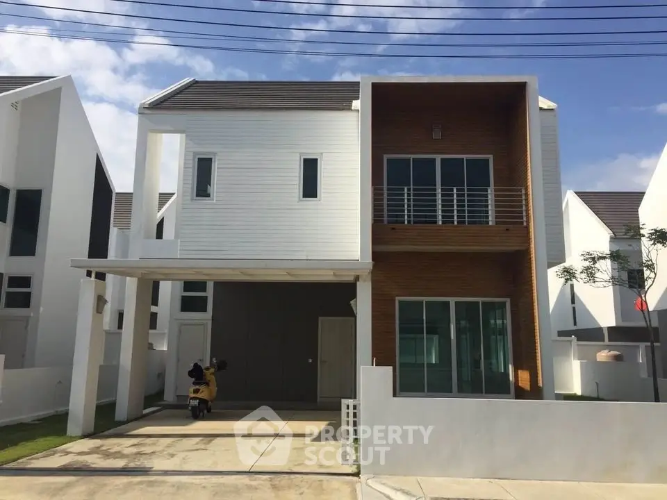 Modern two-story house with sleek design and spacious driveway in a suburban neighborhood.