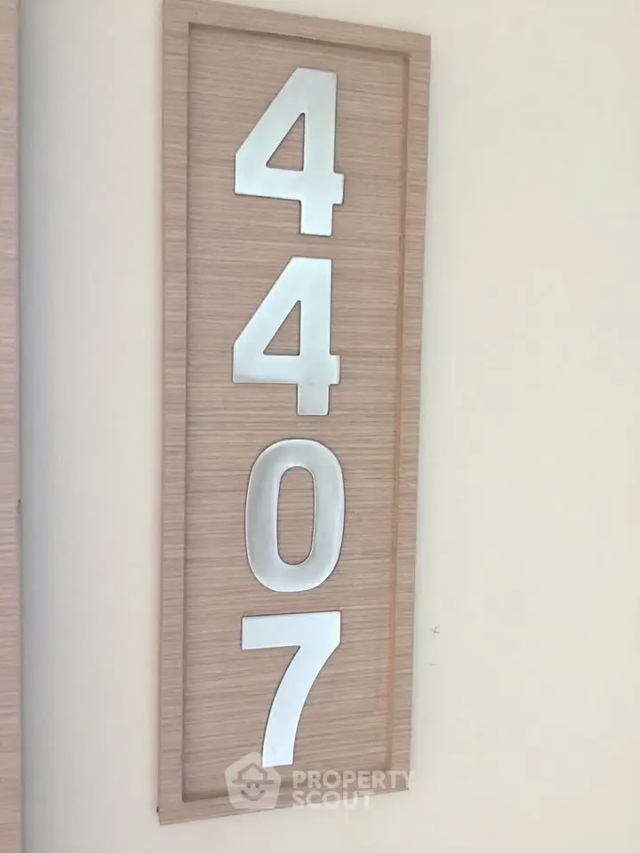Modern apartment number 4407 on stylish wooden plaque, perfect for contemporary urban living.