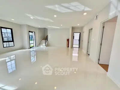 Spacious modern living room with glossy tile flooring and abundant natural light