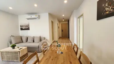 Modern living room with wooden dining table and cozy sofa, perfect for relaxation.