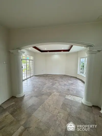 Spacious living room with elegant columns and large windows for natural light