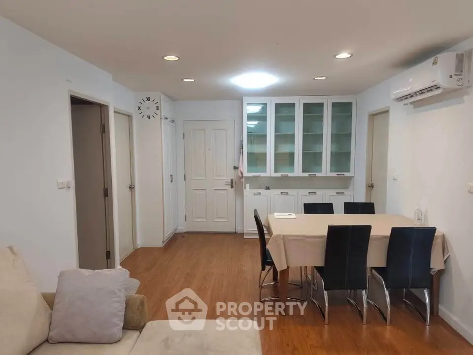 Spacious living room with dining area and modern furnishings in a cozy apartment.