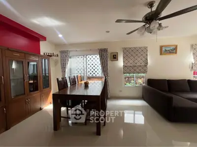 Spacious living room with elegant dining set and cozy sofa, perfect for family gatherings.