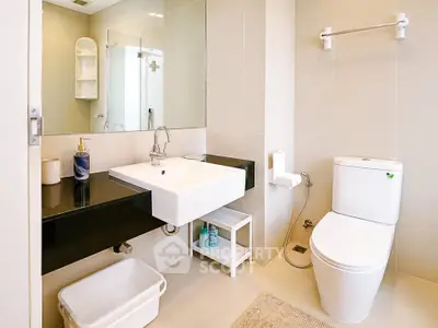 Modern bathroom with sleek fixtures and neutral tones, featuring a stylish sink and toilet.