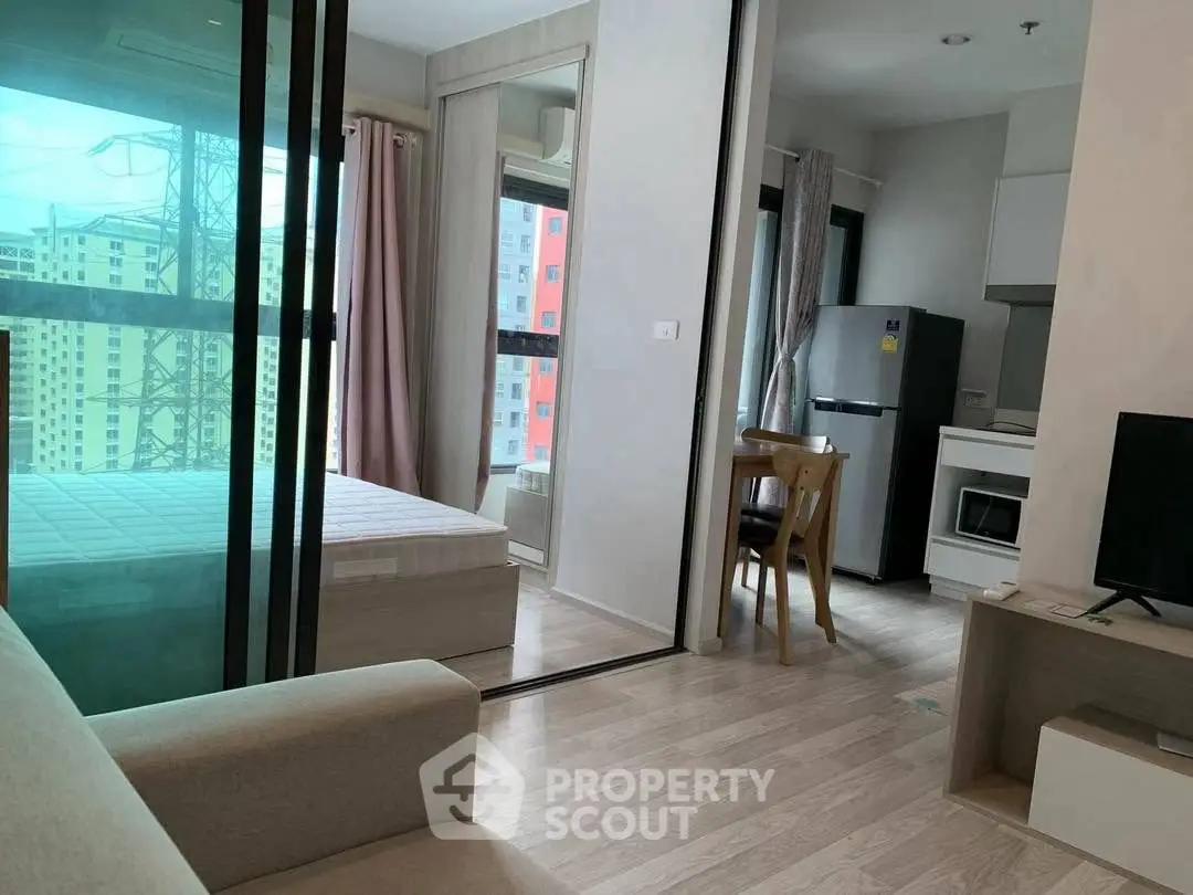 Modern studio apartment with open layout and sleek kitchen appliances.